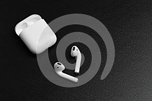 Air Pods with Wireless Charging Case. New Airpods 2019 on black background. entangled 3.5 headphones - Image photo