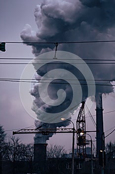 Air pollution, close up of big smoking pipe. Dramatic gray industrial landscape