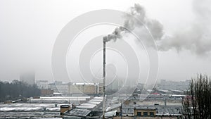 Air pollution. Dark smoke from pipe in the industrial zone with grey sky. Gloomy city landscape.