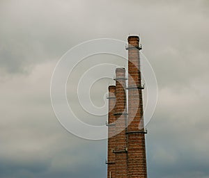 Air pollution from smoke coming out of three factory chimneys. The concept of air pollution, environmental problems