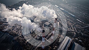 Air pollution by smoke coming out of two factory chimneys. Aerial view