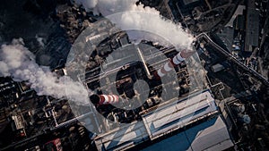 Air pollution by smoke coming out of two factory chimneys. Aerial view