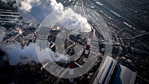 Air pollution by smoke coming out of two factory chimneys. Aerial view