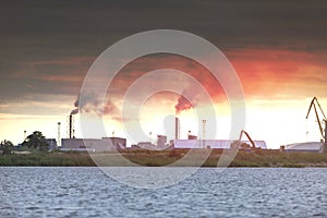 Air pollution by smoke coming out of two factory chimneys. Industrial zone in the city