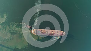 Air pollution by sulphur SOx and nitrous oxides NOx from big cargo ship diesel engine, aerial top down view. MARPOL
