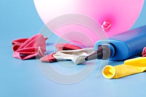 Air-pump inflating a pink ballon on a blue background