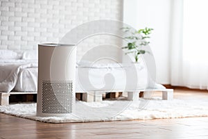 Air purifier in cozy white bed room for filter and cleaning removing dust PM2.5 HEPA in home