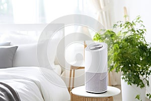 Air purifier in cozy white bedroom for filter and cleaning removing dust PM2.5 HEPA and virus in home