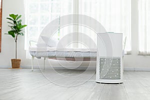 Air purifier in cozy white bedroom for filter and cleaning removing dust PM2.5 HEPA and virus in home,for fresh air and healthy