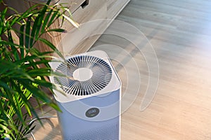 Air purifier on floor in comfortable home. Fresh air and healthy life.