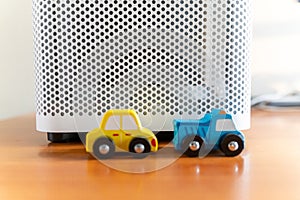 An air purifier with a toy car placed nearby. eco-friendly car concept photo
