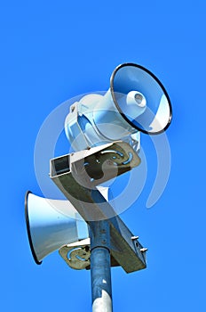 Air raid siren against blue sky photo