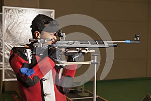 Air rifle shooter aiming. side view