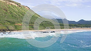 Air shot on Oahu Hawaii Island. Drone flies over Sandy Beach. View of the rocky mountains. Warm sunny day on a tropical