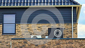 air source heat pump unit installed outdoors at a modern home with bricks in the Netherlands