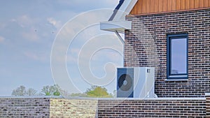 air source heat pump unit installed outdoors at a modern home with bricks in the Netherlands