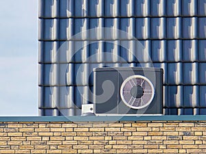 air source heat pump unit installed outdoors at a modern home with bricks in the Netherlands