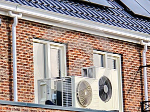 air source heat pump unit installed outdoors at a modern home with solar panels in the Netherlands