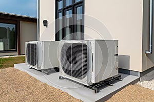 Air source heat pumps installed on the garden front of a modern house. Renewable energy concept