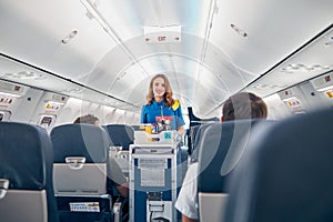 Air stewardess serving food on the board commercial airplane