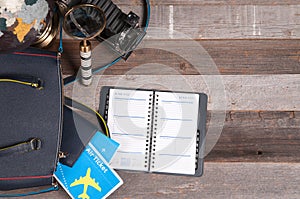 Air ticket, globe and bag on wood background