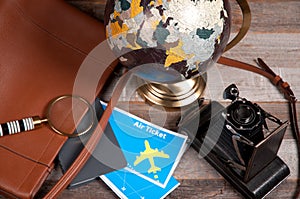 Air ticket, globe and bag on wood background