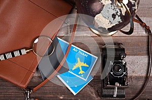 Air ticket, globe and bag on wood background