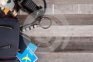 Air ticket, globe and bag on wood background