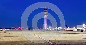 Air Traffic Control Tower after with fueling trucks on soft blue night sky