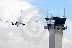 Air traffic control tower with jet airplane photo