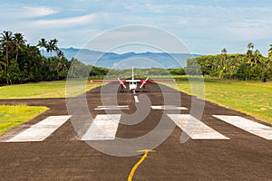 Air travel in Fiji, Melanesia, Oceania. A small propeller airplane just landed to a remote airstrip. Levuka town, Ovalau island.