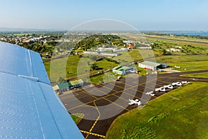 Air travel in Fiji, Melanesia, Oceania. View of hangars, helicopters and small planes on Nausori Suva International Airport apron.