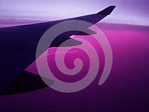 Air travel plane wing wih violet sky