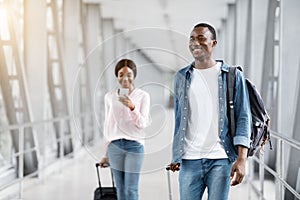 Air Travelling. Happy Smiling Black People Walking With Suitcases In Airport Terminal