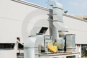 Air ventilator system in large commercial building, Air flow ventilate fan machine with smoke filter duct outside roof building photo