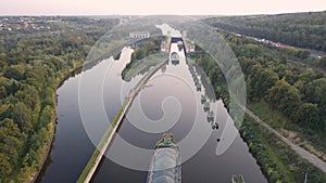 Air view of the movement of the barge on the shipping channel in the area of locks and construction of the bridge