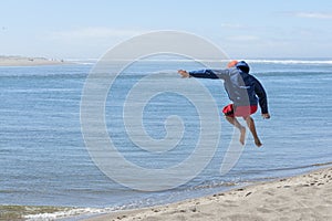 Airborne child after jumping off of sand dune