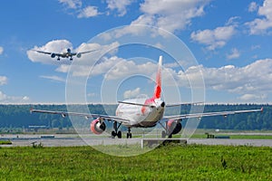 Airbus A319 of VIM-AVIA on the taxiway of the airport waiting for permission to take off, and the approaching Dreamliner