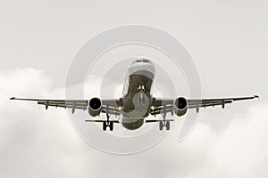 Airbus a320 landing landing in cloudy sky.