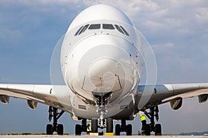 Airbus A380 Jumbo Jet take-off preparation by ground crew people at Berlin airport - low front nose view