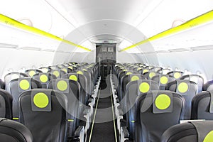 aircraft cabin, seats, portholes, empty plane without passengers. Rows of gray leather seats and windows in the aisle of