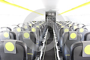 aircraft cabin, seats, portholes, empty plane without passengers. Rows of gray leather seats and windows in the aisle of