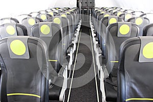 aircraft cabin, seats, portholes, empty plane without passengers. Rows of gray leather seats and windows in the aisle of