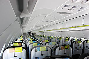 aircraft cabin, seats, portholes, empty plane without passengers. Rows of gray leather seats and windows in the aisle of