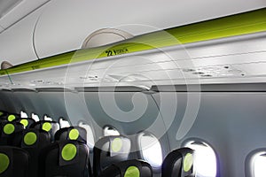 aircraft cabin, seats, portholes, empty plane without passengers. Rows of gray leather seats and windows in the aisle of