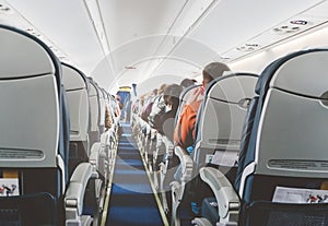 Aircraft cabin after take off. inside the plane. passengers sit on the seat in the cabin ECOM class in Boeing. the passage between