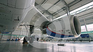 Aircraft engine in the hangar. Airplane turbine detail, plane in hangar. Engine of the airplane under heavy maintenance