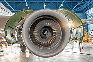 Aircraft engine jet with open hood on the sides in the hangar for maintenance