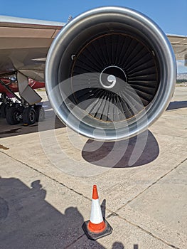 An aircraft engine on the wing of an airplane parked at Paphos Airport against a beautiful blue sky