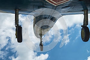 Aircraft fighter on take-off with chassis released from the bottom view against a blue cloudy sky close-up. photo